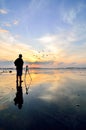 Silhouette of a photographer looking to the birds flying