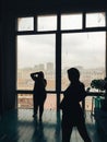 Silhouette of the photographer and model in the studio on the background of huge windows Royalty Free Stock Photo