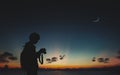 Silhouette of photographer standing in nature background with moon and night sky. Royalty Free Stock Photo