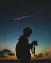 Silhouette of photographer standing in nature background with shooting star and night sky. Royalty Free Stock Photo