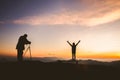 Silhouette of photographer taking photo with model on mountain at sunset, professional wedding photography Royalty Free Stock Photo