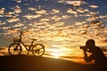 Silhouette of photographer taking pictures a bicycle at sunset Royalty Free Stock Photo