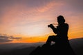 Silhouette of a photographer on top of a mountain at sunset Royalty Free Stock Photo