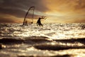 silhouette photography of man playing kite surf and wind surf over rushing sea level against beautiful sunset sky Royalty Free Stock Photo