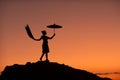 Silhouette picture of a beautiful woman standing in an umbrella on a rock In the middle of the Mekong River