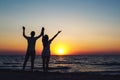 Silhouette picture of a loving couple holding hands at sunset on the sea Royalty Free Stock Photo