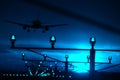 Silhouette of plane landing, runway lights, blue effect Royalty Free Stock Photo