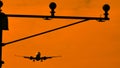 Silhouette of plane landing, runway lights, orange effect Royalty Free Stock Photo