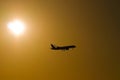 Silhouette of a plane at sunset against the background of an orange sky