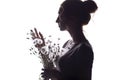 Silhouette portrait of a girl with a bouquet of dry flowers, face profile of a dreamy young woman on a white isolated background Royalty Free Stock Photo