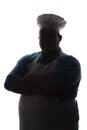 Silhouette of a pot-bellied good-natured funny chef in a hat, male cooker folded his arms over his chest on a white isolated backg Royalty Free Stock Photo