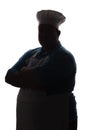 Silhouette of a pot-bellied good-natured funny chef in a hat, male cooker folded his arms over his chest on a white isolated backg Royalty Free Stock Photo