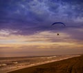 The Silhouette of powered paraglider soaring flight over the sea against sunset sky Royalty Free Stock Photo