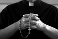 Praying priest with rosary beads