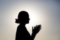 Silhouette of praying woman over sunrise