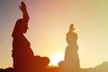 Silhouette of pregnant mother and son doing yoga on beach Royalty Free Stock Photo