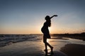 Silhouette of pregnant woman doing yoga and exercise on beach in the sea sunset. Royalty Free Stock Photo