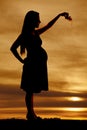 Silhouette pregnant woman holding baby shoes Royalty Free Stock Photo