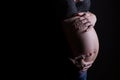 Silhouette of a pregnant woman holding her pregnancy belly with copy space on the left Royalty Free Stock Photo