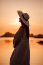 The silhouette of a pregnant woman at sunset. The silhouette of a young woman in a straw hat holding her pregnant belly Royalty Free Stock Photo