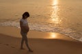 Silhouette of a pregnant woman walking on the beach Royalty Free Stock Photo