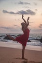 Silhouette pretty woman in red dress on ocean beach at sunset background Royalty Free Stock Photo