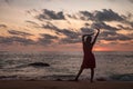 Silhouette pretty woman in red dress on ocean beach at sunset background Royalty Free Stock Photo