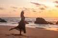 Silhouette pretty woman in red dress on ocean beach at sunset background Royalty Free Stock Photo