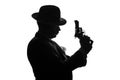 Silhouette of private detective with a gun in right hand. Agent stay side to camera and looks like mafioso Al Capone. Criminal Royalty Free Stock Photo