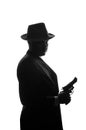 Silhouette of private detective with a gun in right hand. Agent stay side to camera and looks like mafioso Al Capone. Criminal Royalty Free Stock Photo