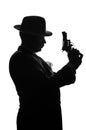 Silhouette of private detective with a gun in right hand. Agent stay side to camera and looks like mafioso Al Capone. Criminal Royalty Free Stock Photo