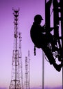 Silhouette of professional industrial climber in helmet and uniform works at height for instaling communication