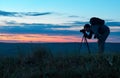 Silhouette of a professional photographer using a tripod, taking a photo Royalty Free Stock Photo