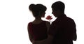 Silhouette profile of a guy and girl looking at each other on white isolated background, a man with a rose flower for a woman