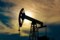 Silhouette of a pumpjack on an oil well against the background of sky Royalty Free Stock Photo