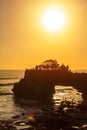 Silhouette of Pura Batu Bolong in golden sunset it the traditional Balinese temple located on a rocky, in the Tanah Lot area, Bali