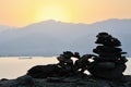 Silhouette of a pyramid of flat stones against the backdrop of a sunset