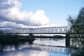 Silhouette of the railway bridge across the river, the reflection of the bridge in the river Royalty Free Stock Photo
