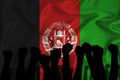 Silhouette of raised arms and clenched fists on the background of the flag of Afghanistan. The concept of power, conflict. With