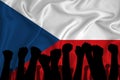 Silhouette of raised arms and clenched fists on the background of the flag of Czech. The concept of power, power, conflict. With