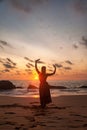 Silhouette pretty woman in red dress on ocean beach at sunset background Royalty Free Stock Photo