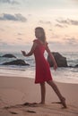 Silhouette pretty woman in red dress on ocean beach at sunset background Royalty Free Stock Photo