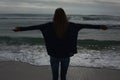 Silhouette rear view of woman with arms outstretched at beach