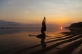 Silhouette and reflection of girl sitting on surfboard at ocean beach on background of beautiful sunset Royalty Free Stock Photo