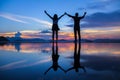 Silhouette and reflection of romantic boy and girl friends holding hands and enjoying sunset at Water front at Western District Royalty Free Stock Photo