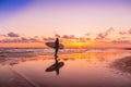 Silhouette and reflection of surfer girl with surfboard on a beach at sunset. Surfer and ocean Royalty Free Stock Photo