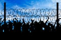 Silhouette of refugees and barbed wire