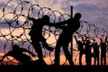 Silhouette of refugees and barbed wire