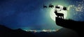 Silhouette of reindeer standing on the cliff to see Santa Claus.