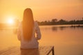 Silhouette of relaxing young woman on wooden pier at the lake in sunset Royalty Free Stock Photo